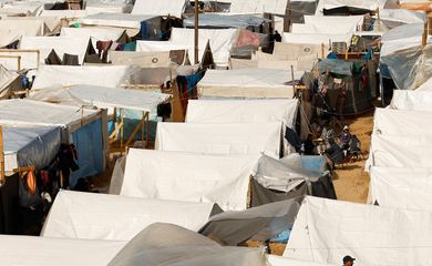 Displaced Palestinians sit by tents, amid the ongoing conflict between Israel and Palestinian Islamist group Hamas, in a tent camp in Khan Younis in the southern Gaza Strip, November 20, 2023. REUTERS/Ibraheem Abu Mustafa