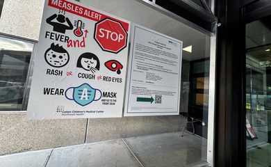 Placa de alerta sobre o sarampo afixada na entrada do Cohen Children's Medical Center, em New Hyde Park, Nova York, EUA 14 de março de 2025 REUTERS/Shannon Stapleton