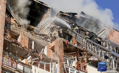 Bombeiros atuam no local de um prédio de apartamentos danificado durante um ataque com drones russos, em meio à ofensiva da Rússia contra a Ucrânia, em Kharkiv, na Ucrânia, em 12 de outubro de 2026. REUTERS/Sofiia Gatilova
