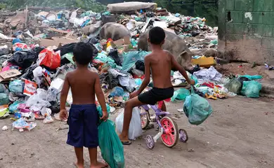 Rio de Janeiro (RJ), 01/04/2026 - Crianças jogam lixo no lixão à beira da Baía de Guanabara, na comunidade Salsa e Merengue. Saneamento básico em localidades do Complexo da Maré. Foto: Tânia Rêgo/Agência Brasil